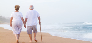 Elderly couple walking on beach